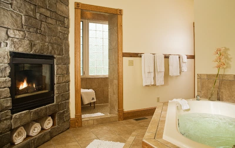 A luxurious bathroom with a fireplace, a jacuzzi tub, and a relaxing atmosphere.